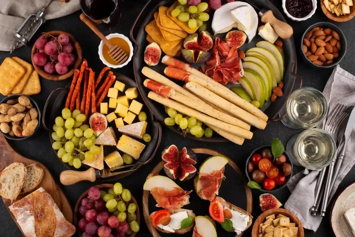 Un delicioso picoteo gourmet con quesos, embutidos, frutas, pan y almendras. Perfecto para compartir.