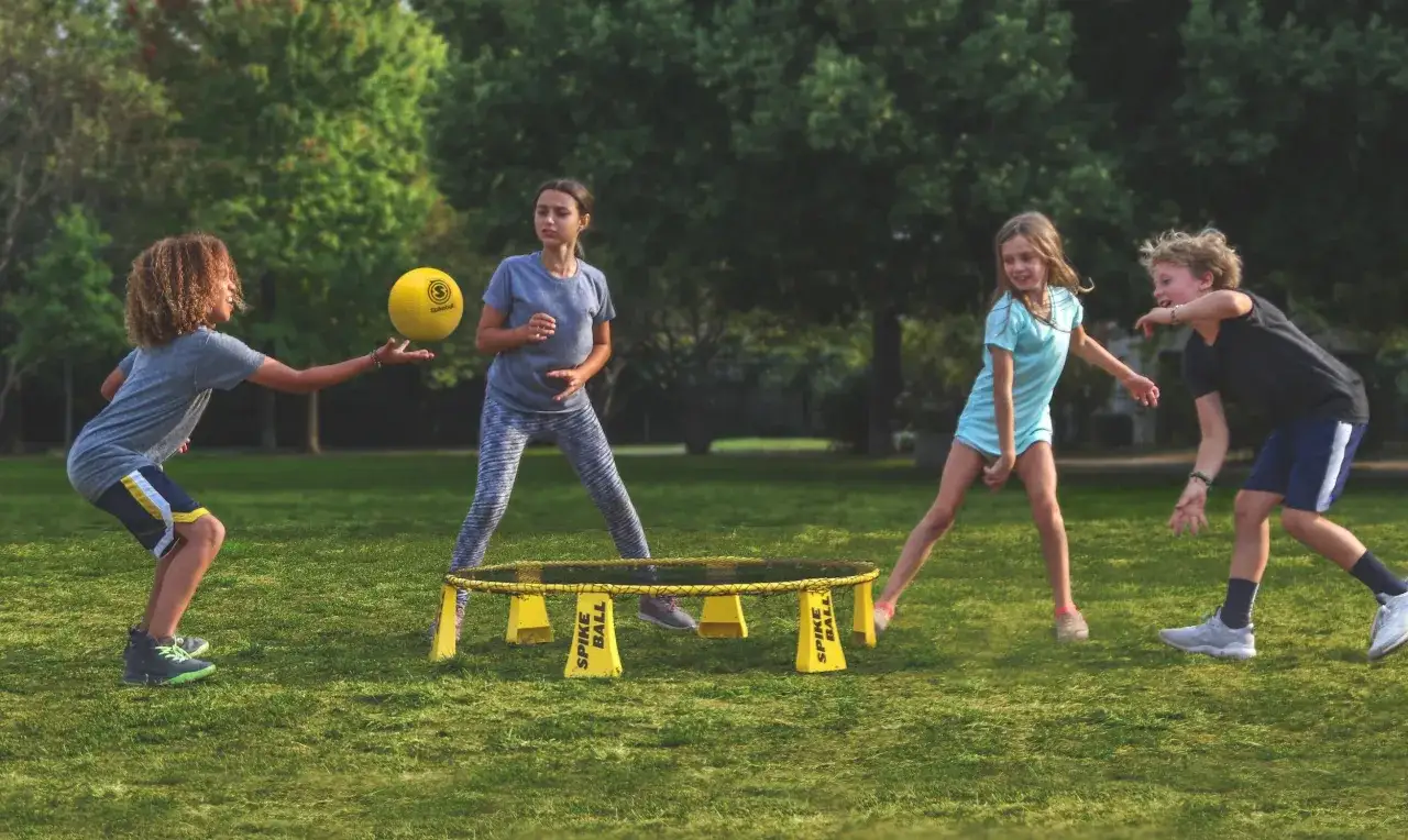 Ni&ntilde;os jugando Spikeball en un parque, fomentando la motivaci&oacute;n personal a trav&eacute;s del deporte y la competencia amistosa.