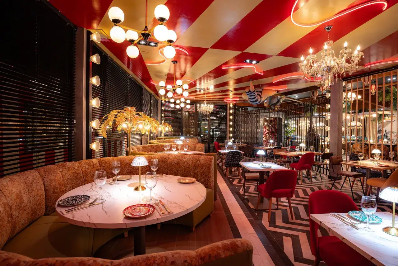 Un restaurante con decoraci&oacute;n vibrante, ideal para tener una cita rom&aacute;ntica. Mesas puestas, luces c&aacute;lidas y un ambiente &uacute;nico.