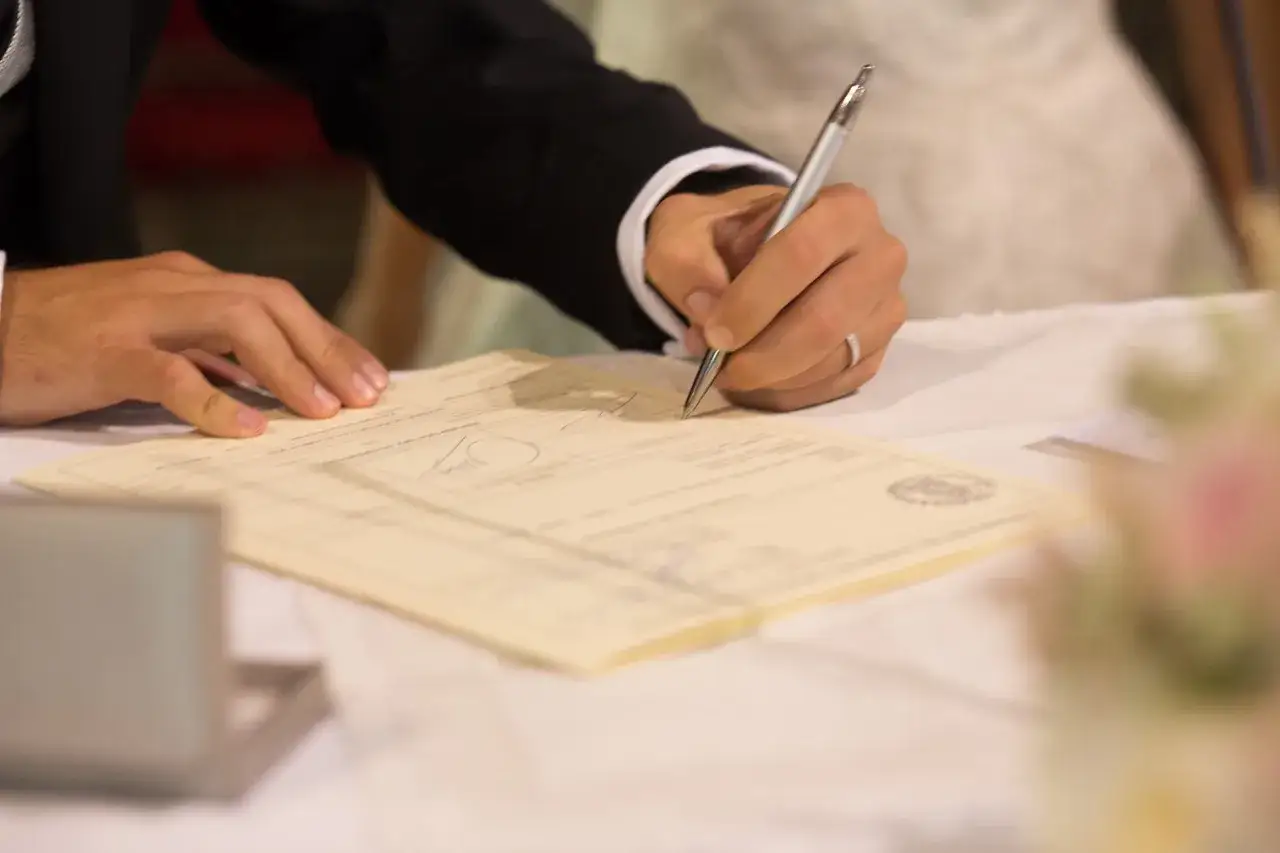 Novio firma documento, cumpliendo los requisitos para casarse por la iglesia.