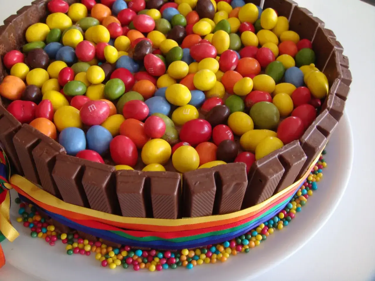Pastel de cumplea&ntilde;os decorado con M&M's de colores y barritas de chocolate, un ejemplo de los variados tipos de tartas de cumplea&ntilde;os.