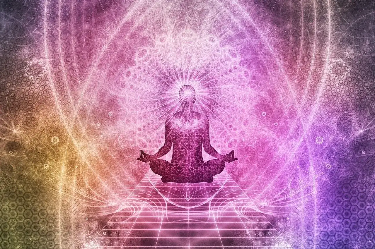 Silueta de persona meditando en posici&oacute;n de loto, rodeada de un aura de luz y patrones geom&eacute;tricos vibrantes. Un s&iacute;mbolo de paz interior y conexi&oacute;n espiritual.