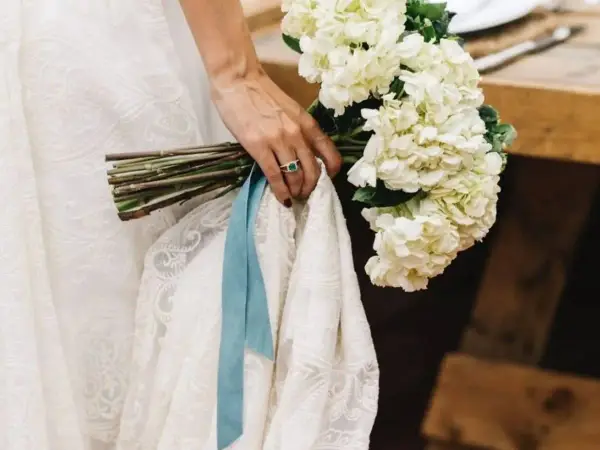 Novia con ramo de hortensias blancas y algo azul: una cinta de seda y un anillo esmeralda.